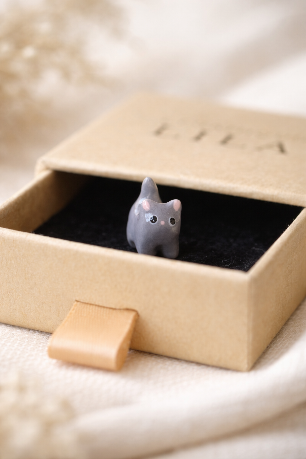 Petit chat en céramique dans une boîte
